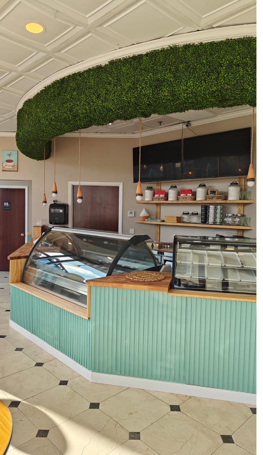 Mint fluted counter and gelato case under a green hedge ceiling