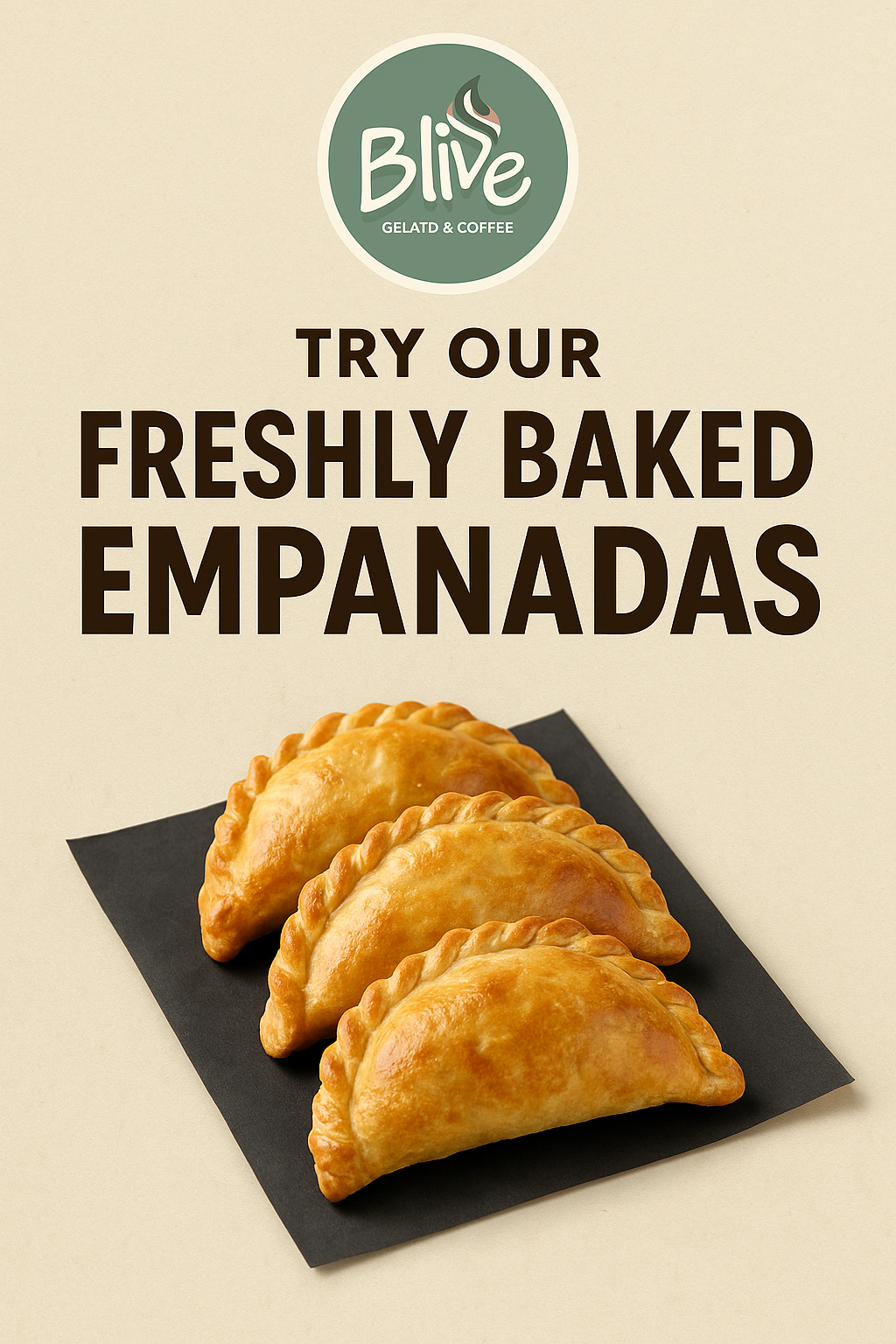 Three golden baked empanadas on dark paper